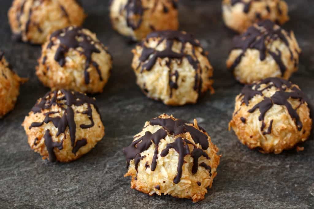 Close up on a macaroon topped with chocolate drizzle.