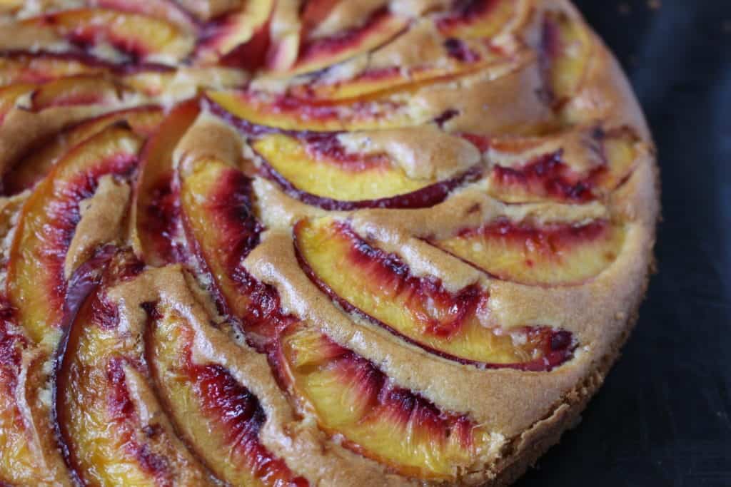 Close up on the peach slices baked over the cake.