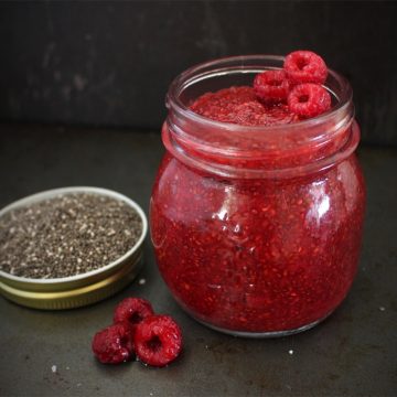 Jam in a glass jar on a black surface.