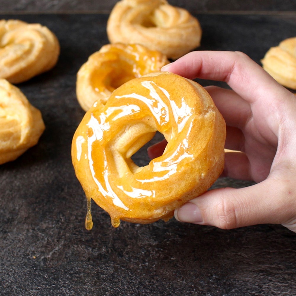 Honey Lemon Glazed Cruller Donut held in a hand