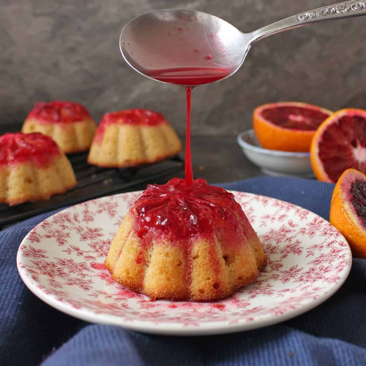 One cake on a pink plate with blood orange juice poured over.