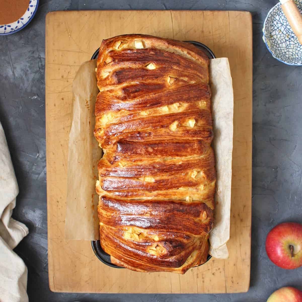 Sweet bread in the baking pan over a wooden board from above