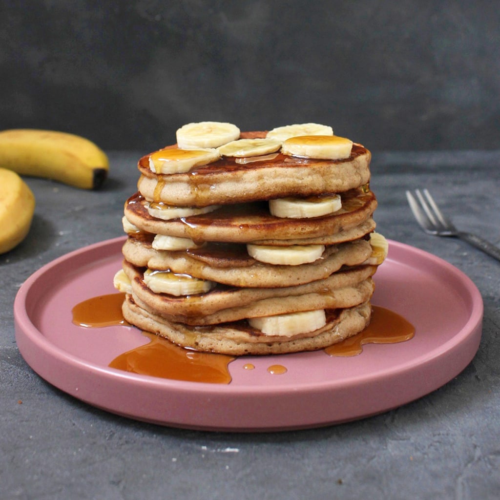 Stack of Buckwheat Banana Pancakes on a pink plate with maple syrup