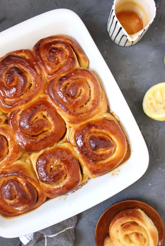 Lemon Rolls topped with lemon drizzle viewed from above in a white baking dish.