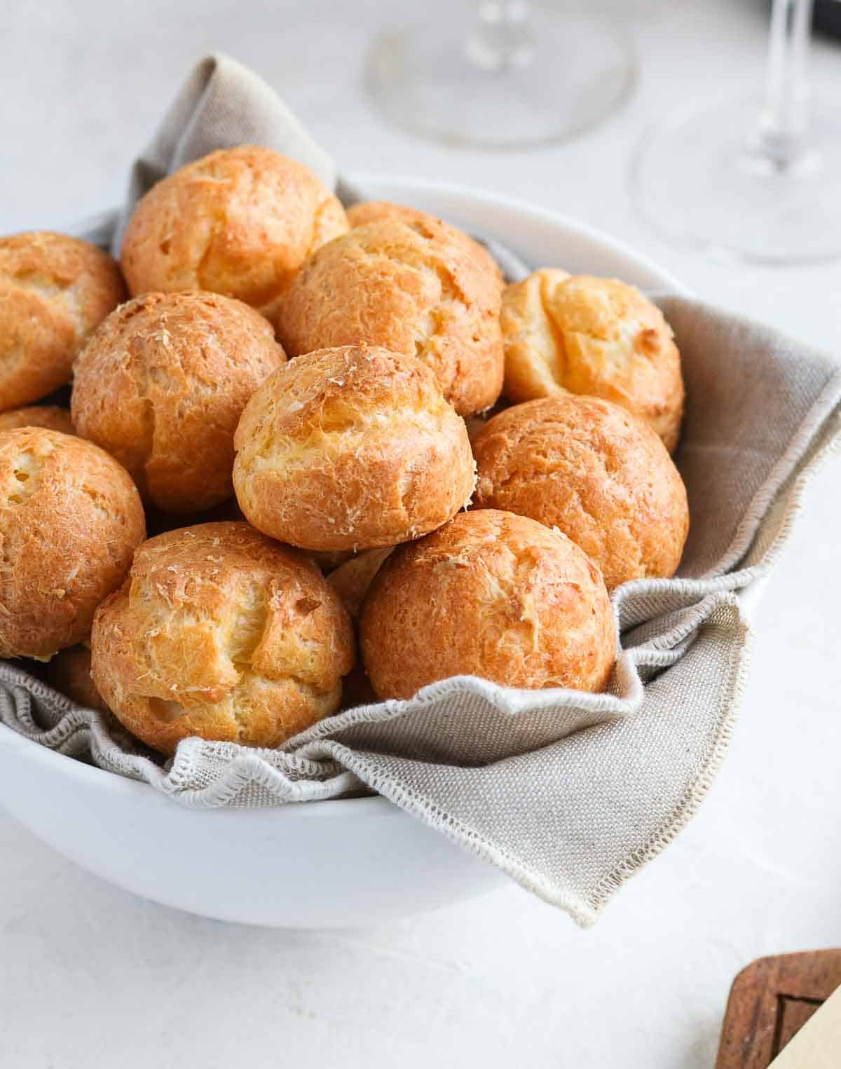 Close up on the cheese puffs inside a white bowl.