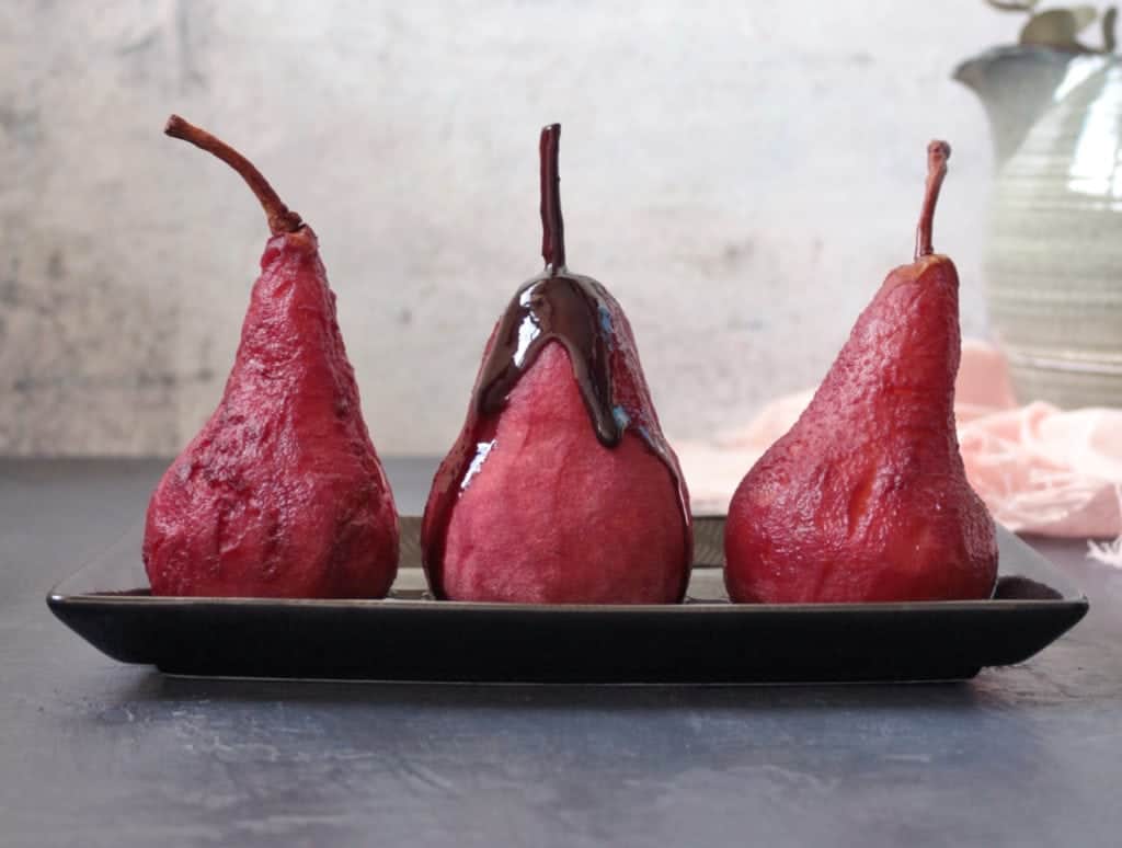 Red wine syrup dripping over a pear