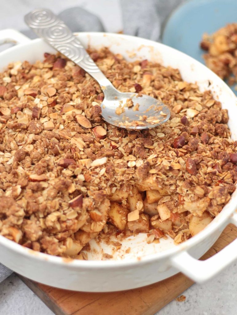 Baked Crumble with a spoon taken off and silver serving spoon.