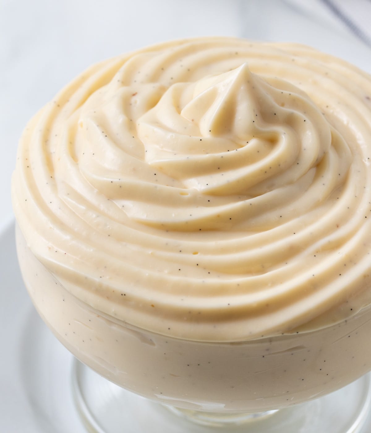 Macro shot of the vanilla cream piped in a glass cup.