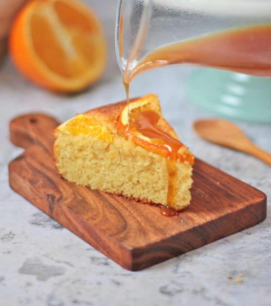 Orange syrup poured over a slice of semolina cake