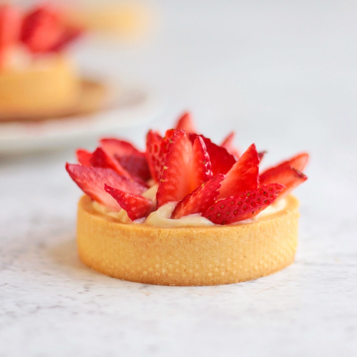 One Strawberry Tartlet on a grey surface