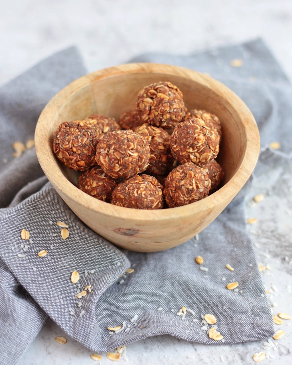 Chocolate Peanut Butter Bliss Balls in a bowl on a grey napkin