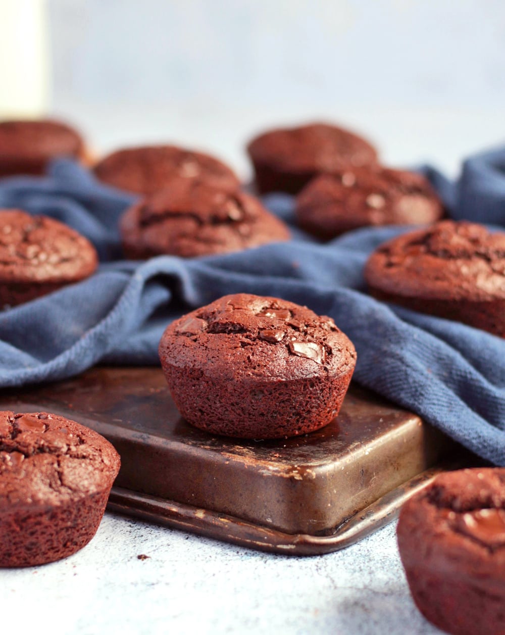 Muffins on the corner of a baking tray with blue napkin