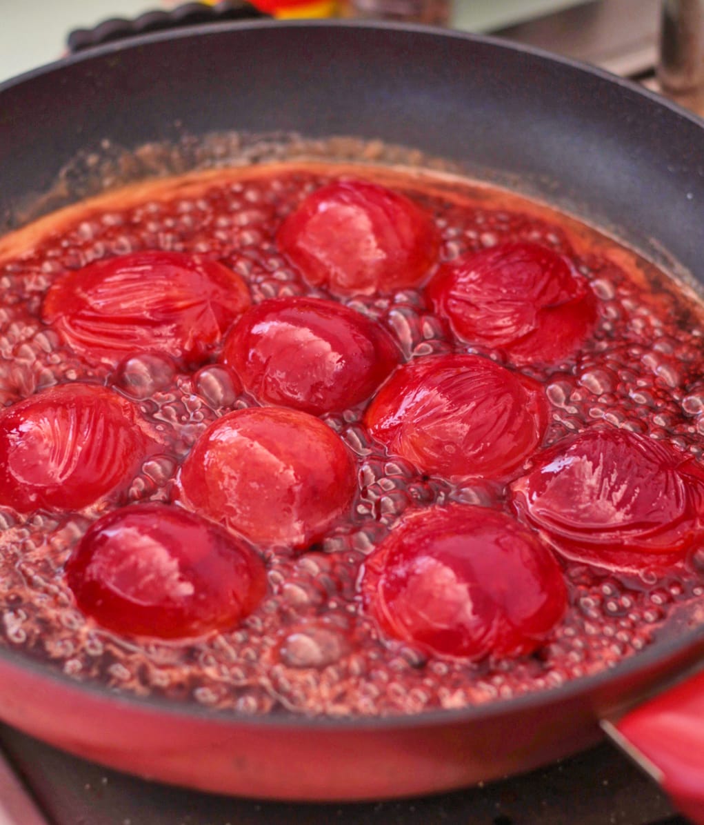 Plums caramelising in a pan.