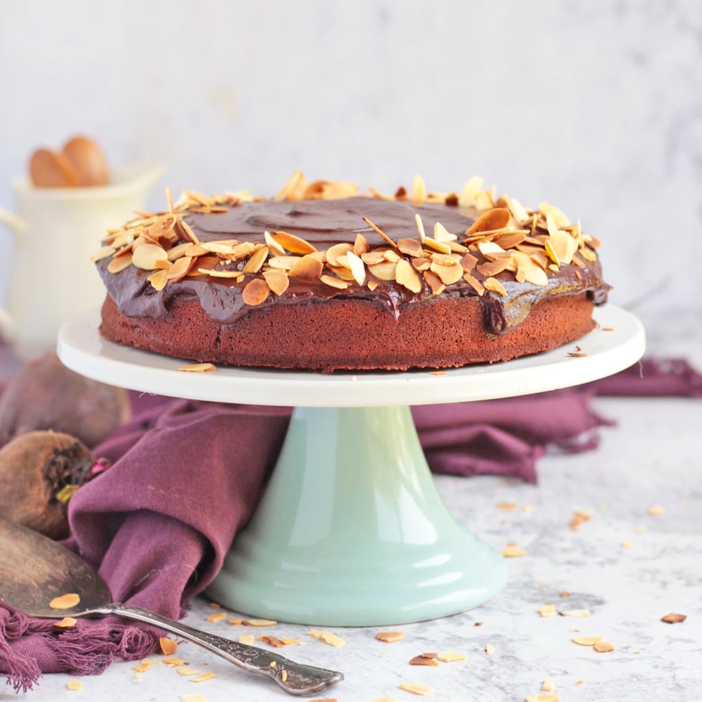 Chocolate Beetroot Cake topped with flaked almonds on a cake stand