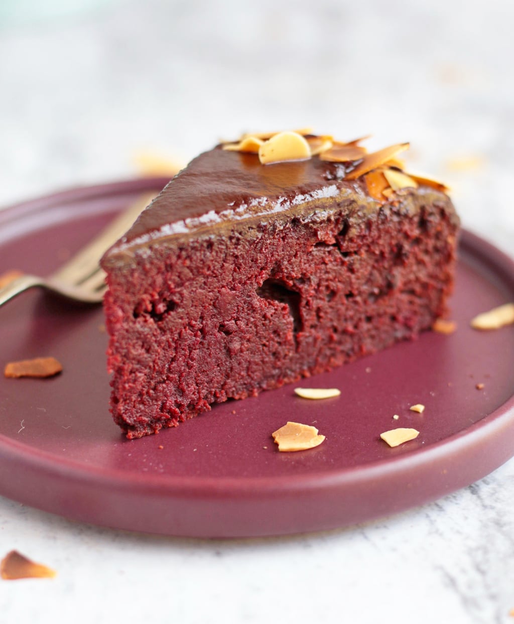 Close up on a slice of beetroot cake with chocolate ganache