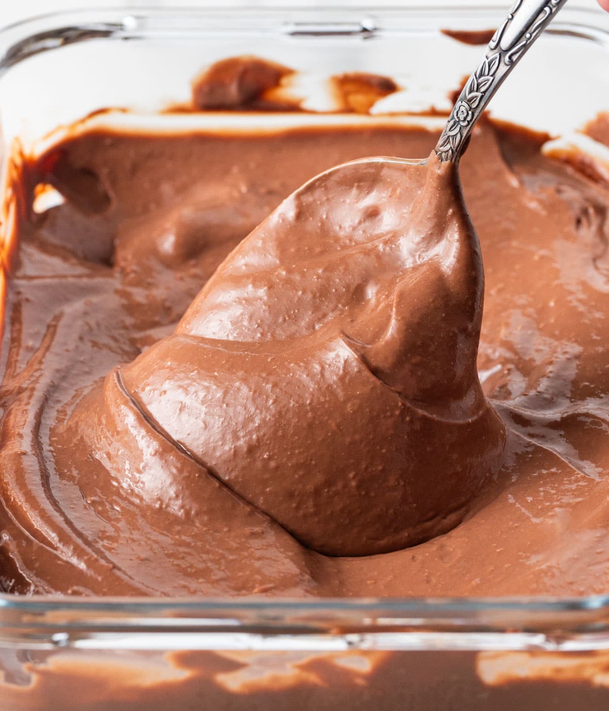 Close up on the chocolate cream falling from a spoon.