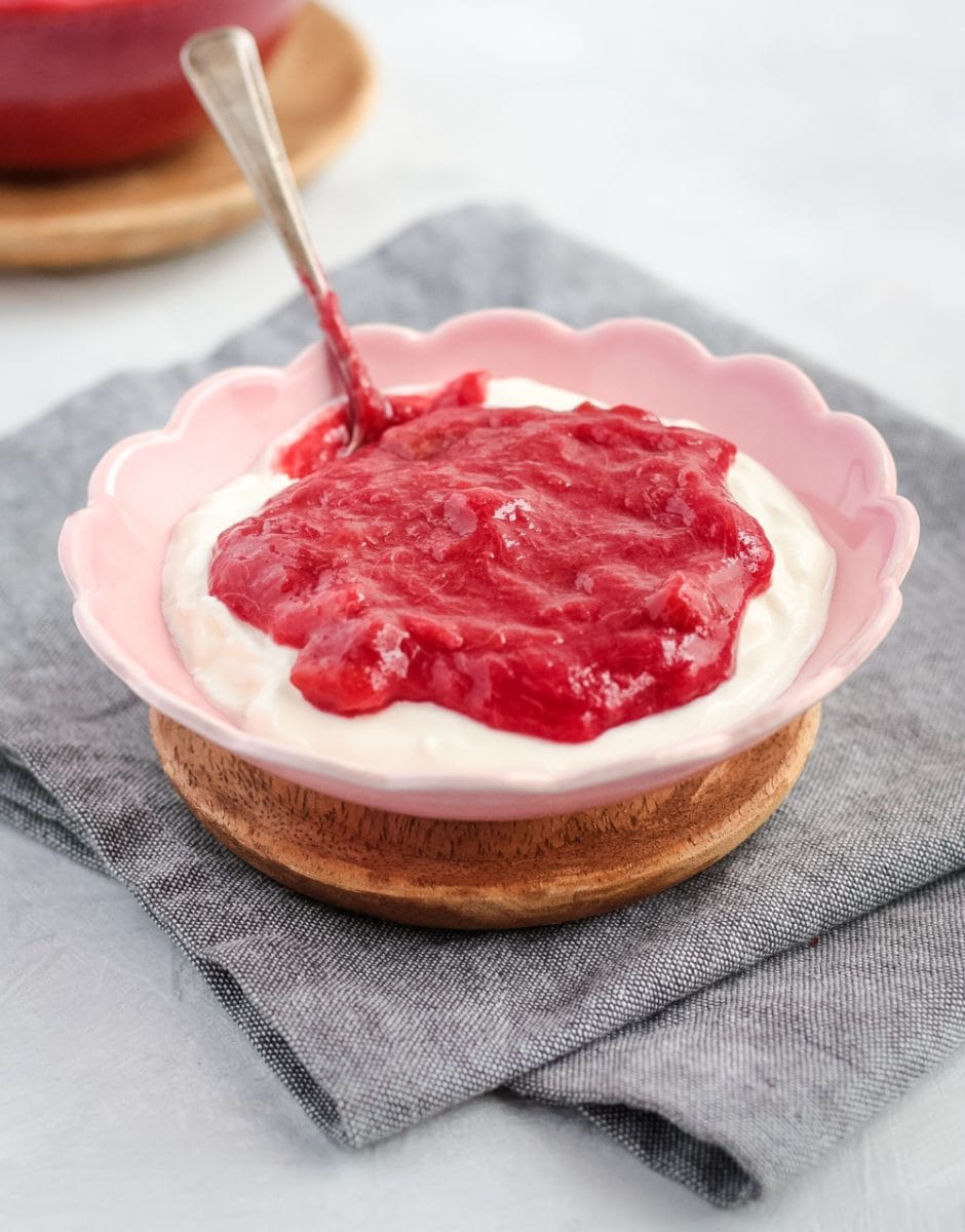 Rhubarb over greek yogurt in a bowl with a spoon