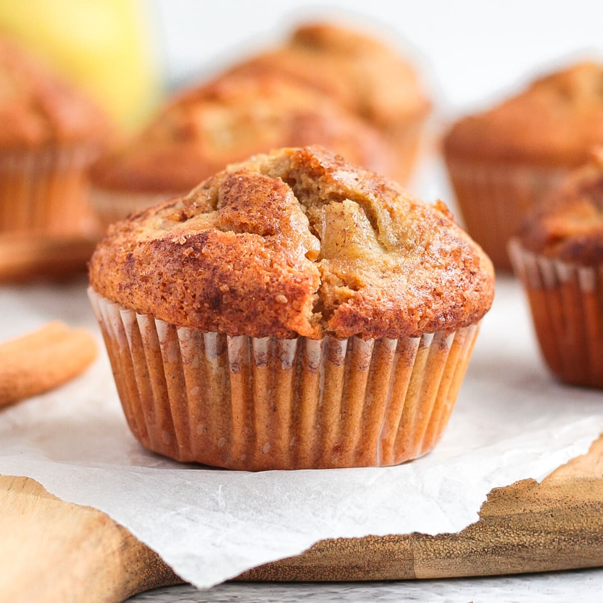 Close up on a pear muffin over baking paper and a wooden board