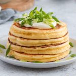 Close up on a stack of 4 pancakes on a white plate