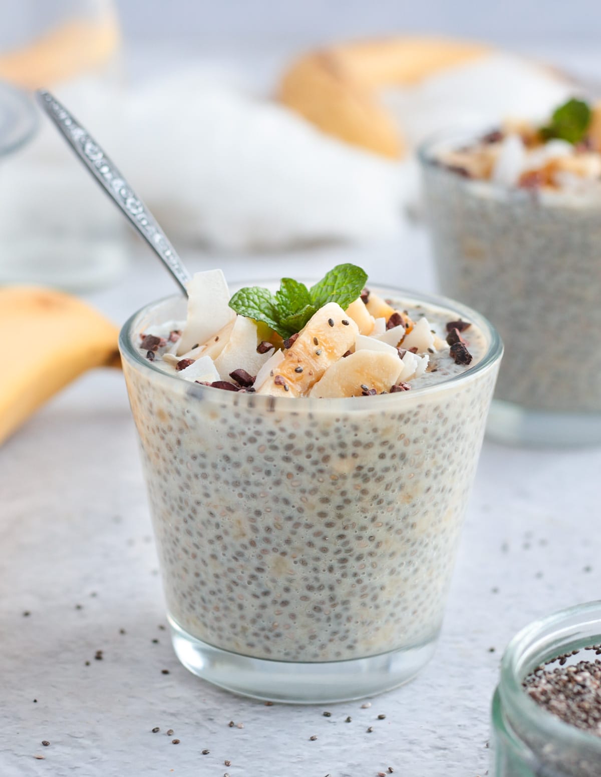 One glass cup filled with pudding with spoon in it