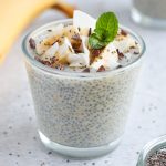 Banana Chia Seed Pudding in a small glass cup topped with coconut, bananas and mint