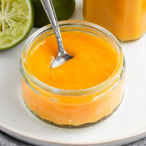 Close up on a glass jar with the coulis and a silver spoon