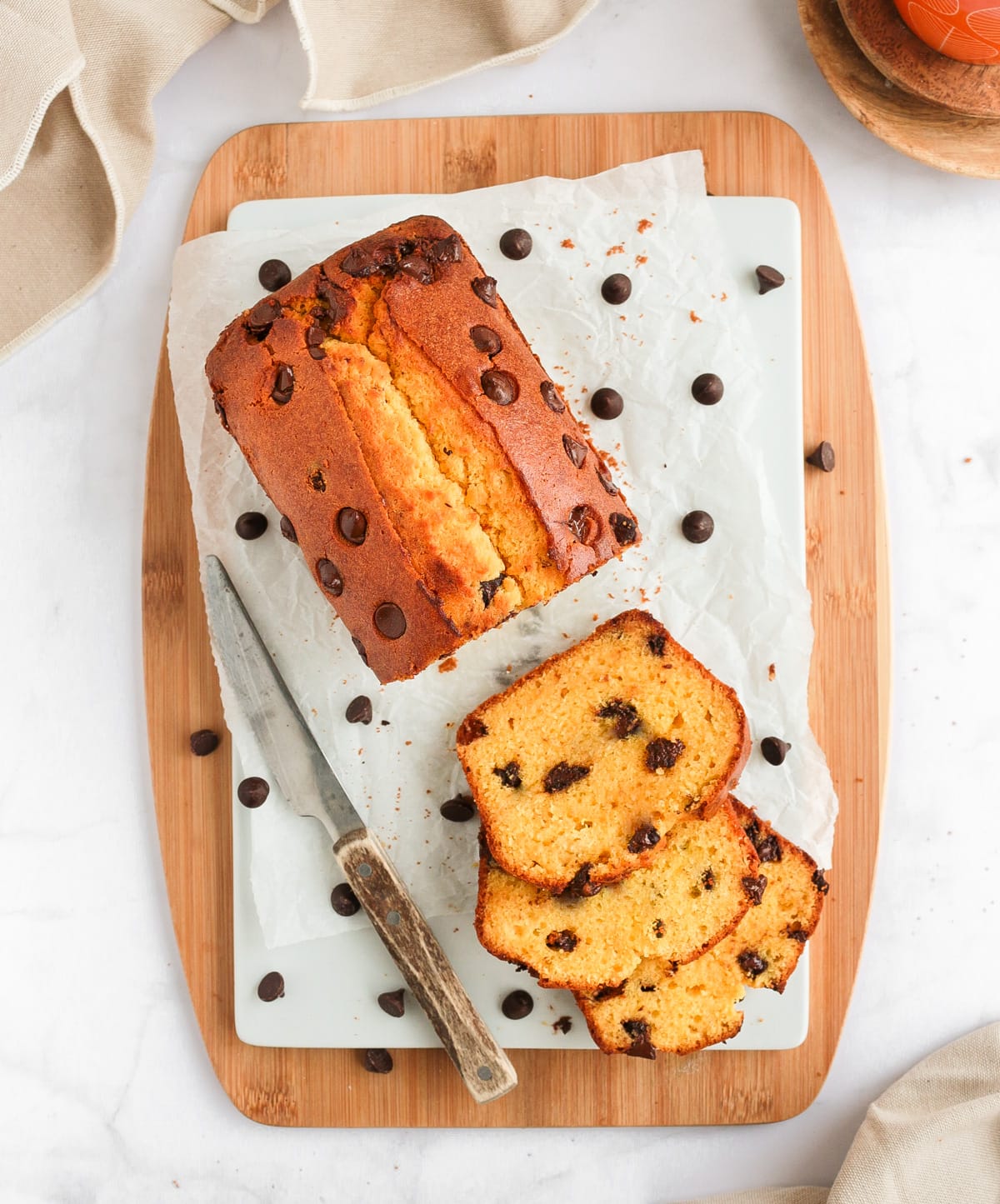 Cake on a white board over a wooden board from above