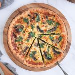 Flatlay photo of the quiche on a round board with 3 slices cut off