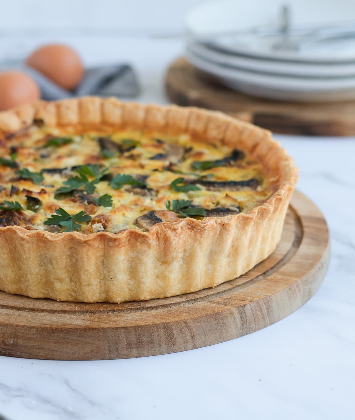 Side view on a quiche over a wooden board