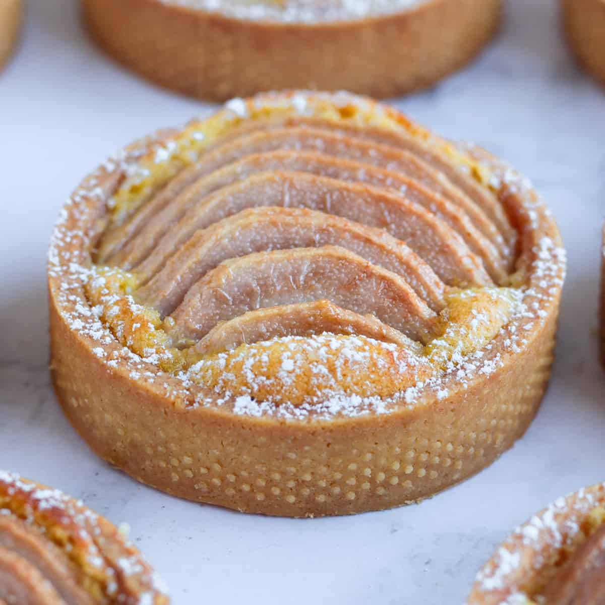 Close up on one tartlet on a grey surface.