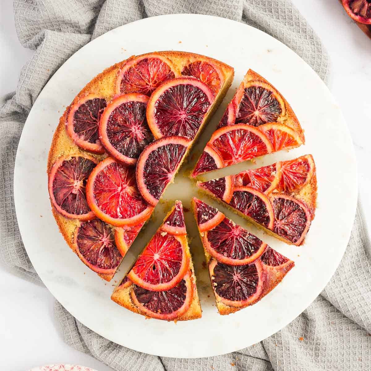 Flatlay photo of the cake on a round white board with 4 slices cut off.