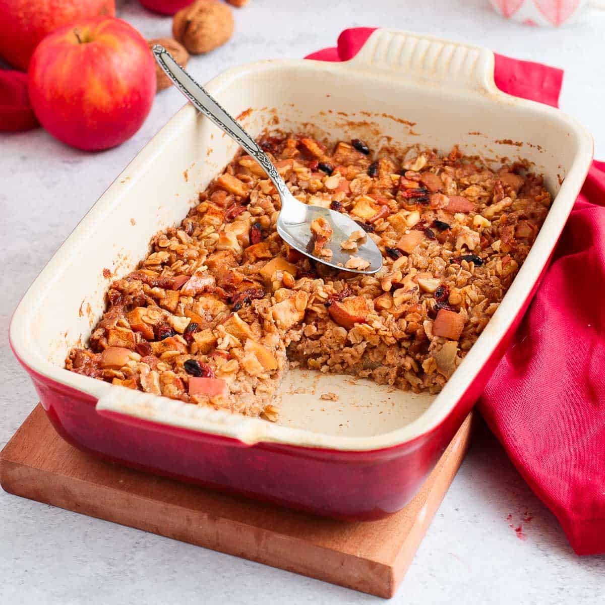 Baked Oatmeal in a white and red ceramic dish with a slice cut off.