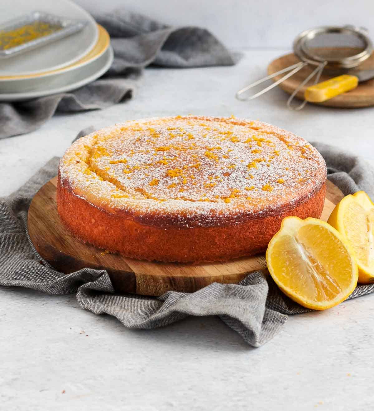 Cake placed over a wooden board on a grey napkin.