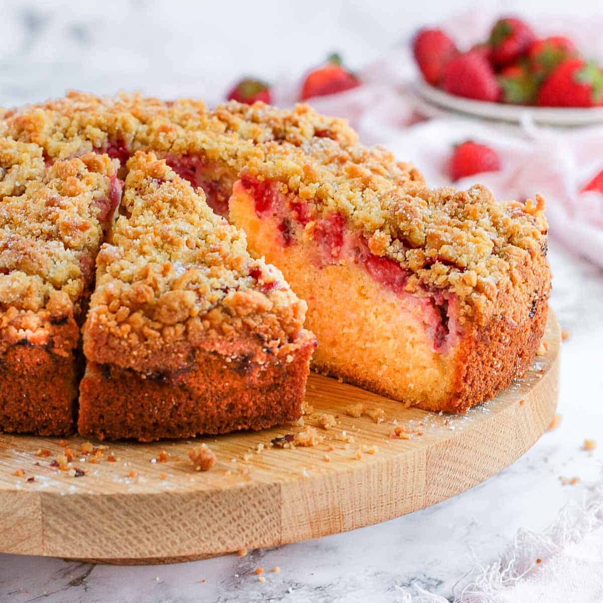 Strawberry Cake on a cake stand with two slices cut off.