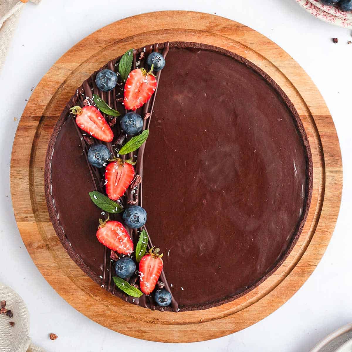 Chocolate Tart from above on a round wooden board.