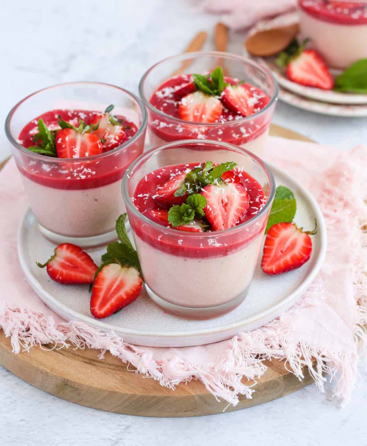 Three panna cottas on a white plate.