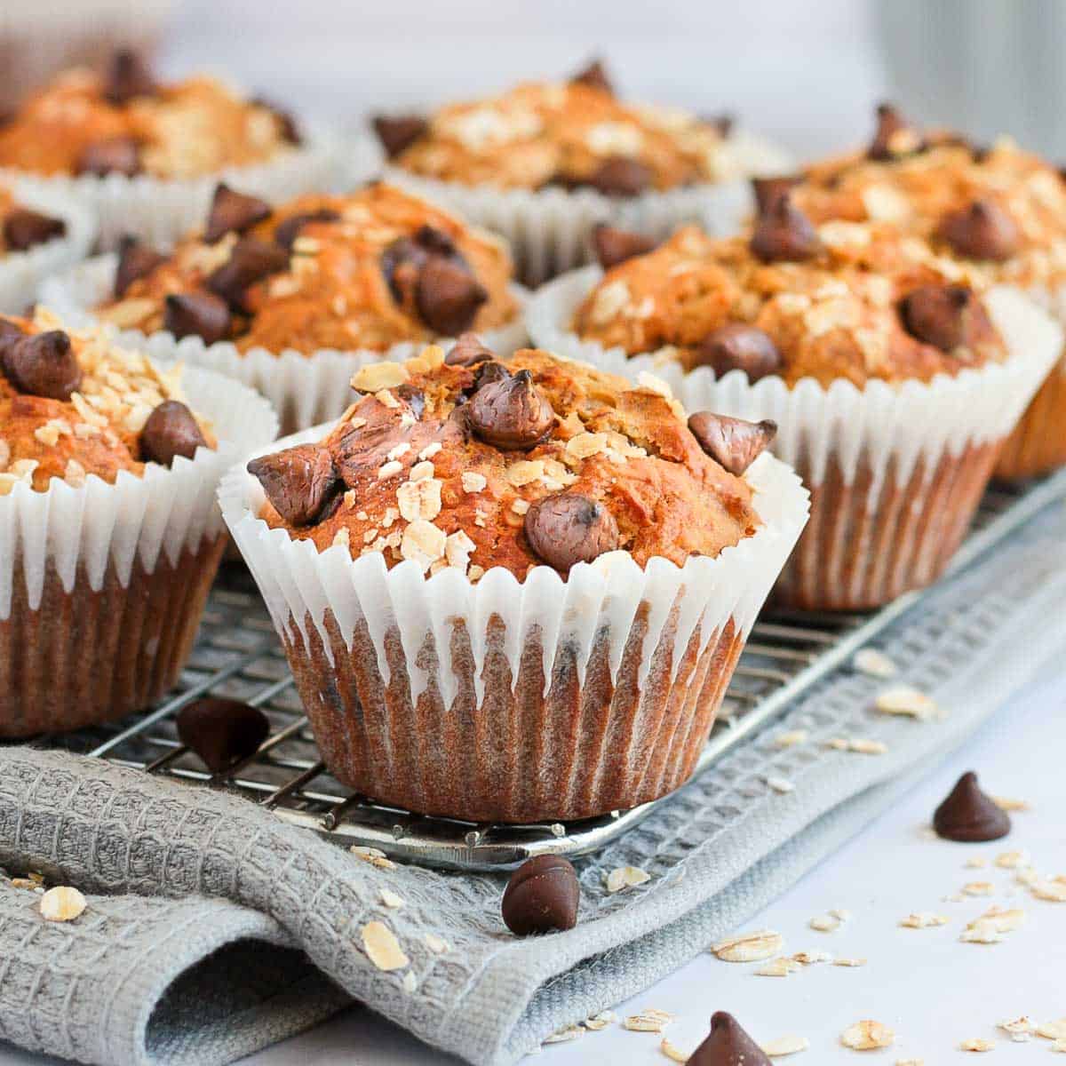 Close up on a muffin on a cooling rack over a grey napkin.