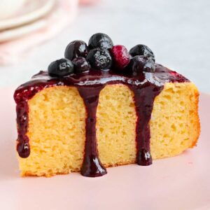 A slice of cake drizzled with the blueberry sauce.