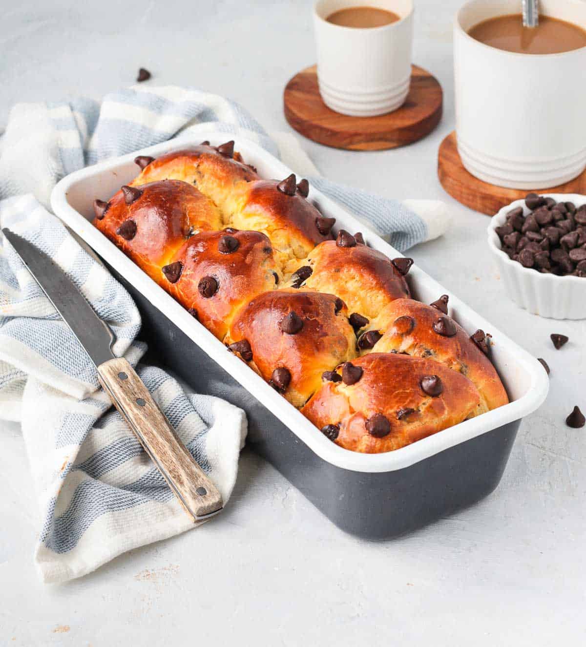 Choc Chip Brioche on the loaf baking pan over a white and blue napkin.