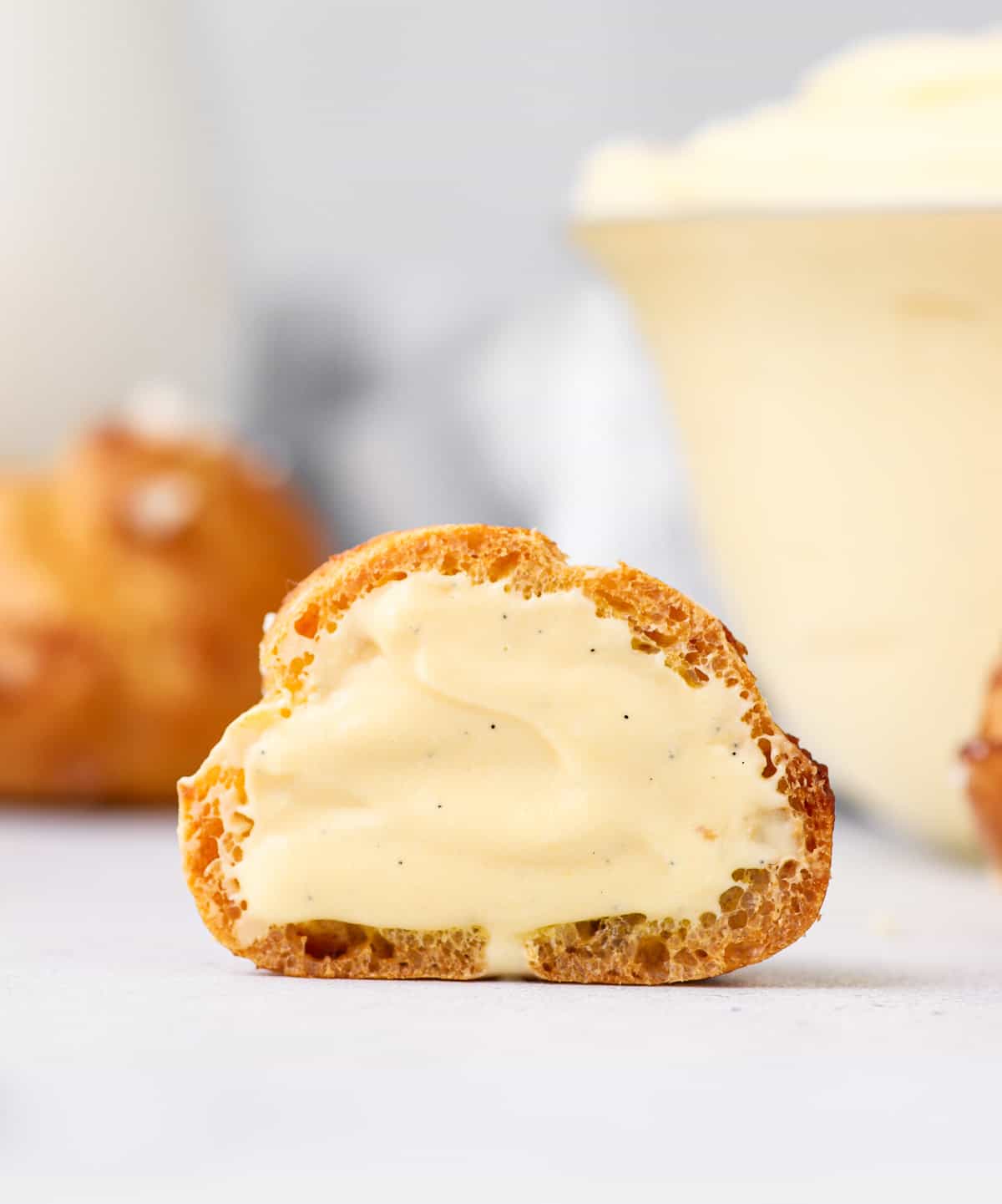 Choux bun cut in half filled with cream.