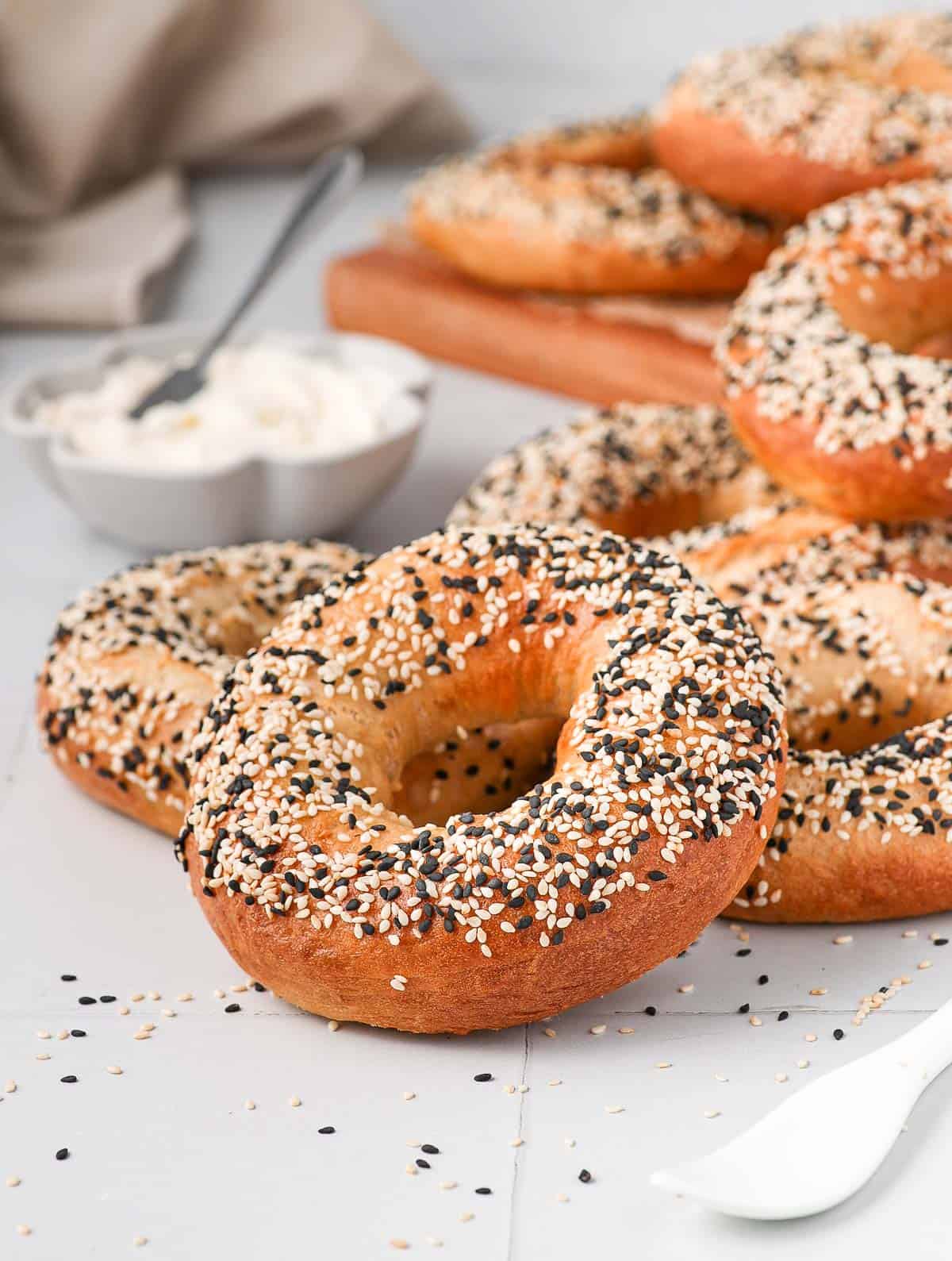 Bagels stacked on a white tiled surface.