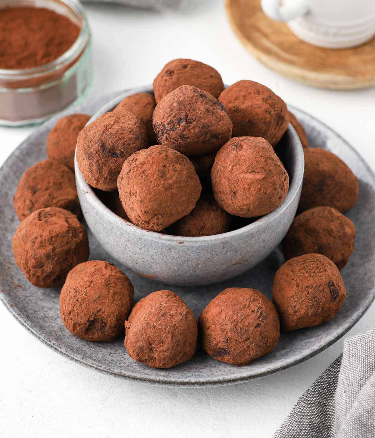 Truffles placed in a grey bowl over a grey plate.