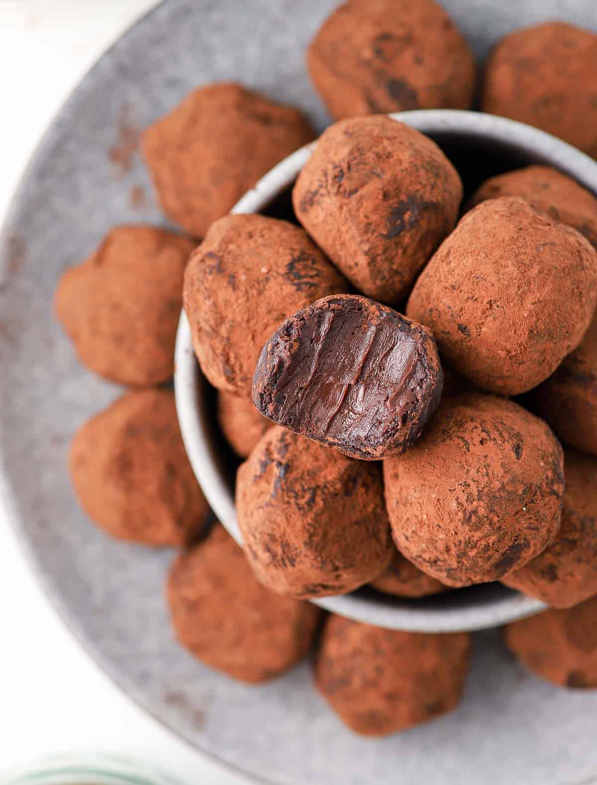 Chocolate balls seen from above stacked in a grey bowl.
