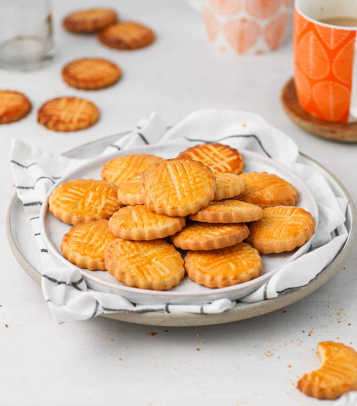 Cookies on two white plates and white tea towel.