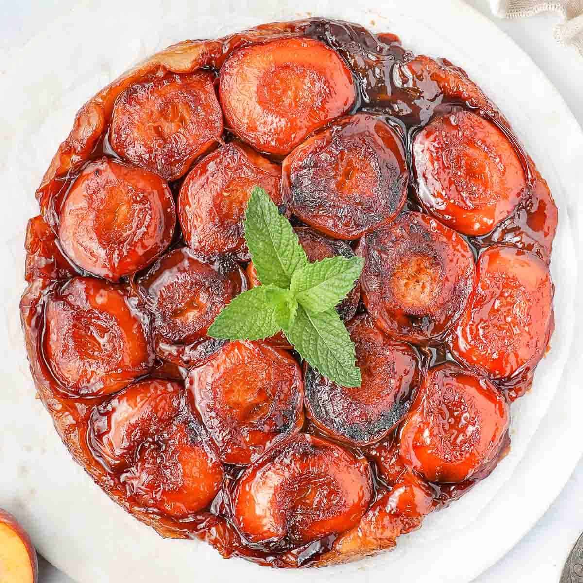 Baked tarte tatin seen from above and topped with mint.