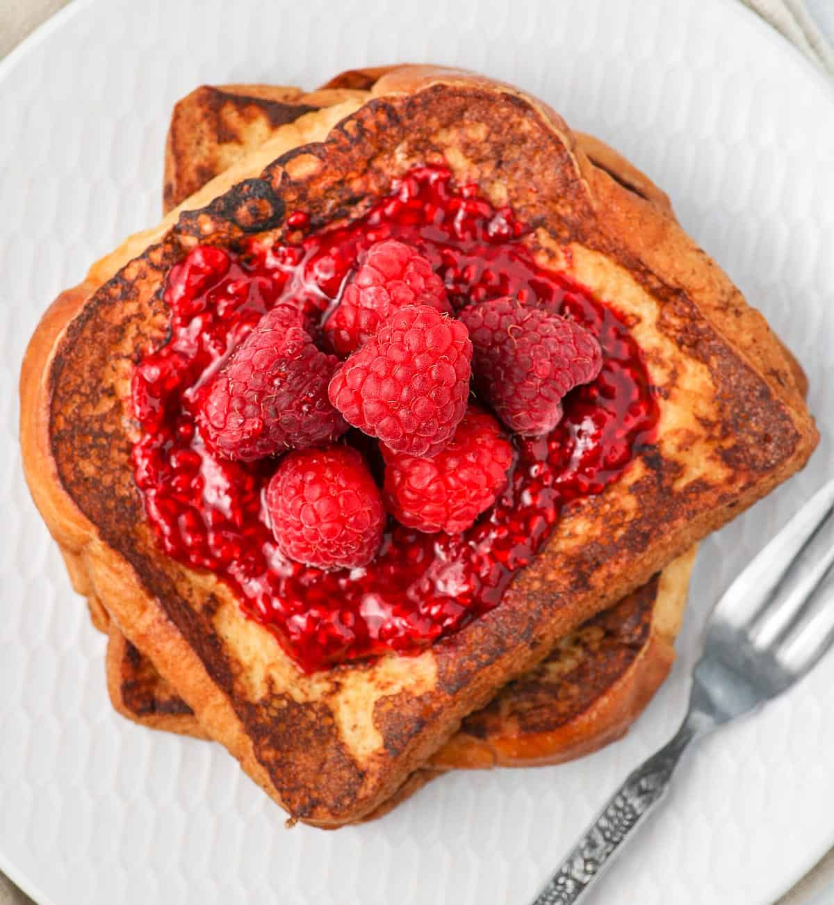 Sauce and fresh raspberries over french toast.