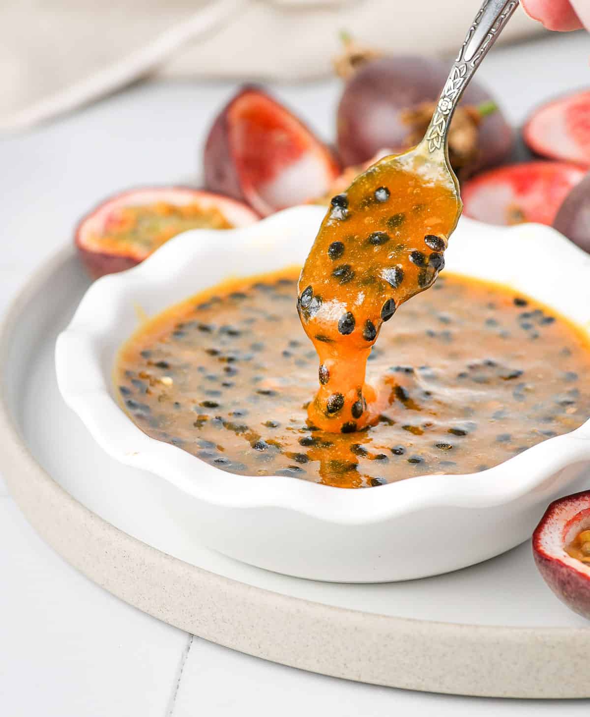 Pouring the coulis from a spoon into the bowl.