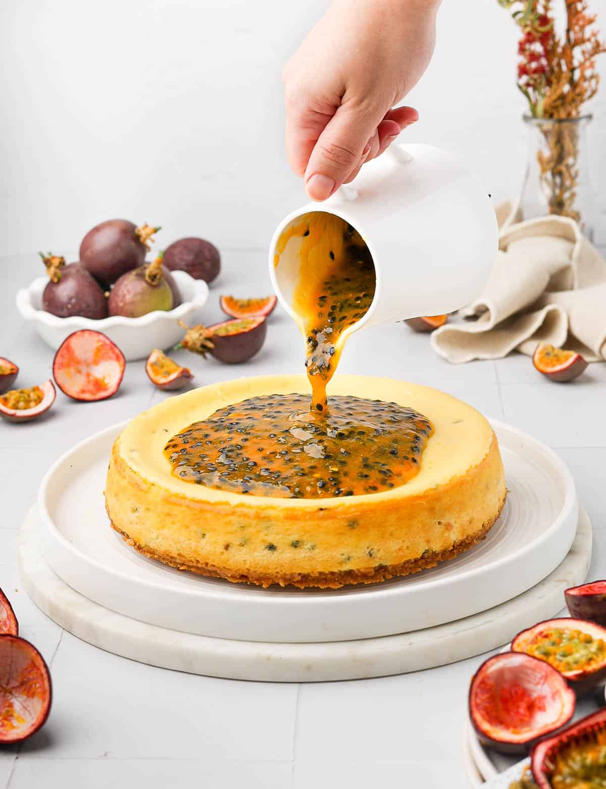 Pouring the passion fruit sauce over a cheesecake.