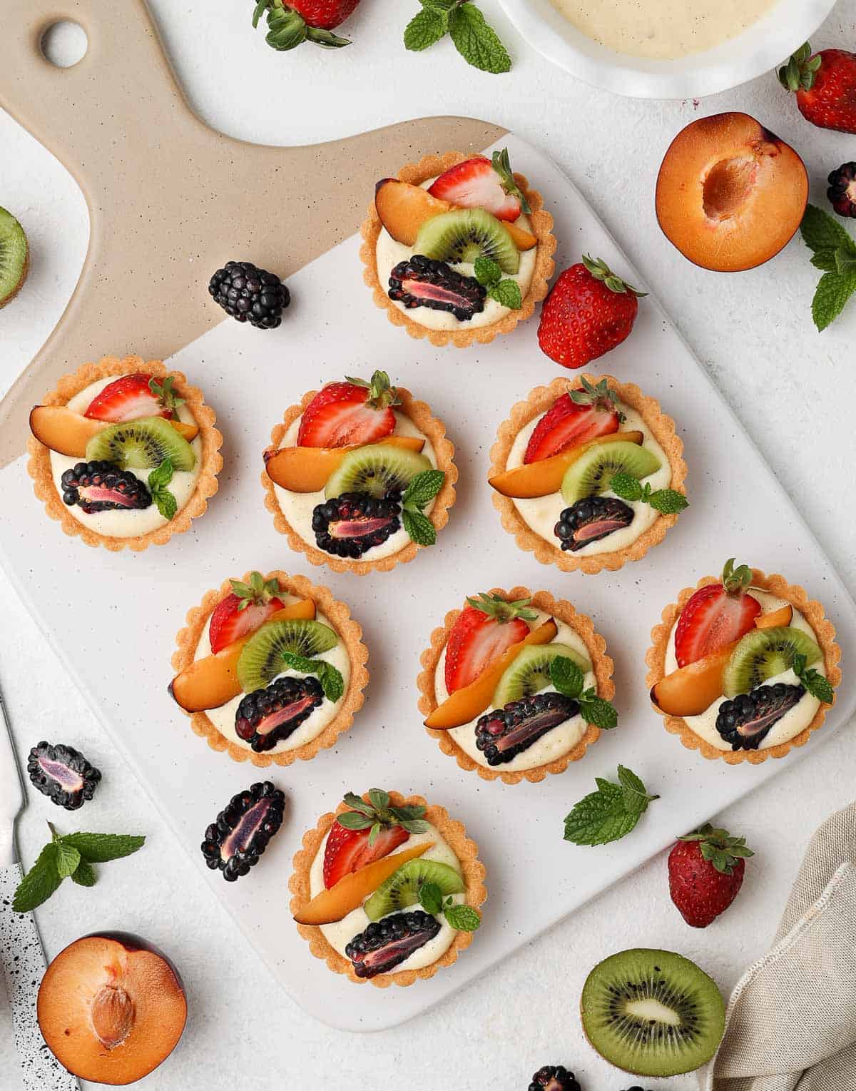 Tartlets on a serving board seen from above.
