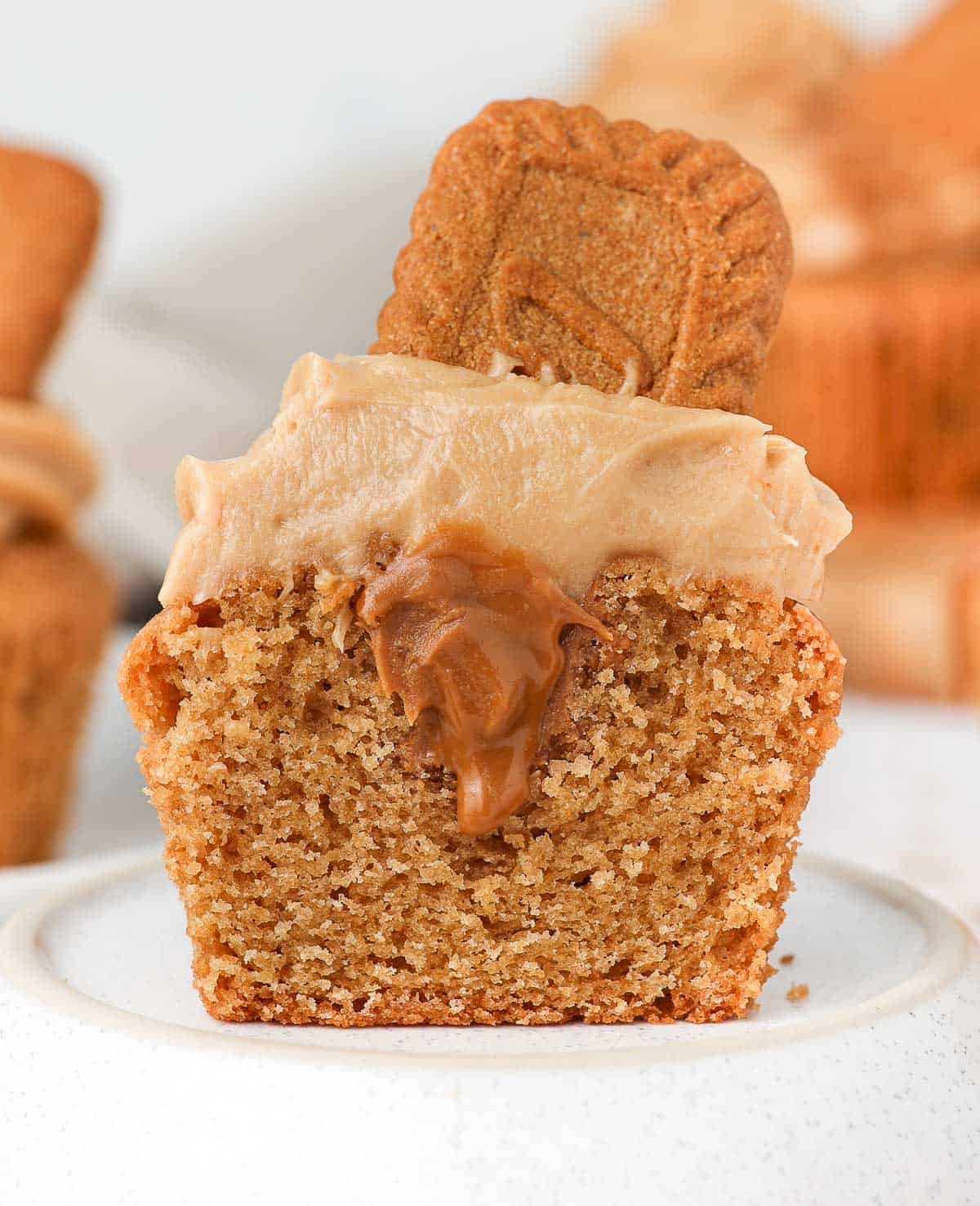 Cupcake cut in half topped with cookie butter frosting.